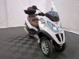 a motor scooter that is parked on a black and white checkered floor