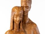 statue of a man and a woman holding a baby on a white background