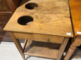 a small wooden table with two cups on it