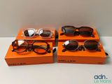 two pairs of sunglasses sitting on top of a box on a table