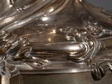 a close up of a silver plate with a clock on it