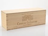 La boîte en bois contient une bouteille de vin posée sur une surface blanche.