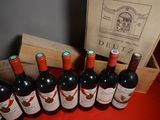 several bottles of red wine are lined up on a table