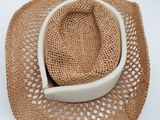 chapeau de paille beige orné d'un ruban blanc et d'un panier blanc sur le dessus