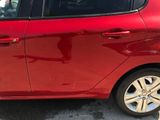 a red car parked in a parking lot next to a parking meter