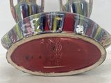 a picture of a red and white bowl with three vases on it