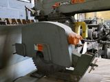a machine that is cutting a piece of wood in a factory