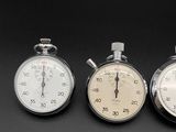 three stopwatchs sitting side by side on a black surface