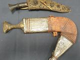 une paire de poignards anciens en argent et or sur fond noir