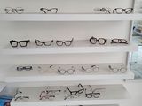 many pairs of glasses on the shelves in the store