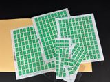 quatre feuilles de timbres verts posées sur une enveloppe jaune