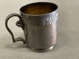 a silver cup that is sitting on a table