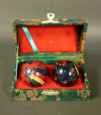 pair of decorative ornaments in a green box on a gray surface