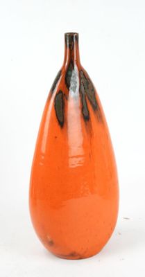 an orange vase that is sitting on a white surface