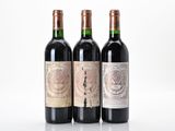three bottles of red wine sit side by side on a white surface