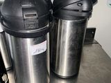 deux cafetières et une machine à café posées sur une table