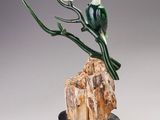 sculpture représentant un oiseau perché sur une branche d'arbre posée sur un rocher