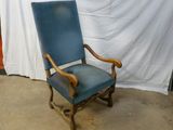 une chaise bleue posée devant un rideau blanc