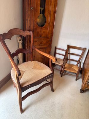 une chaise placée à côté d'une horloge de parquet dans une pièce