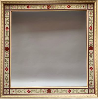 un gros plan d'un miroir accroché au mur, avec une bordure rouge et verte