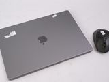 un ordinateur portable et une souris posés sur une surface blanche