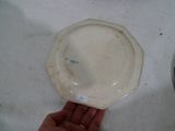 une personne tenant une assiette blanche marquée d'un trait vert