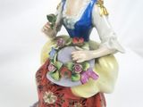 a figurine of a woman sitting on a chair