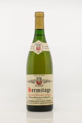 the bottle of wine is sitting on a white surface