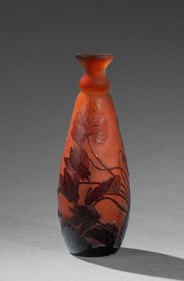 un vase rouge orné d'un motif sur un fond gris