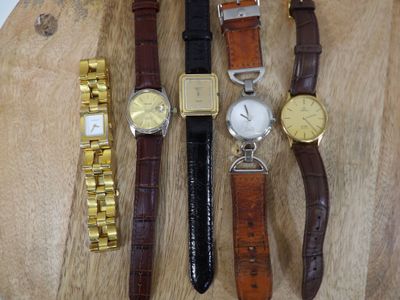 quatre types de montres différents posés sur une table en bois