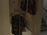 two shirts hanging on a clothes rack in a room