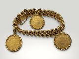 a close up of a gold bracelet with two coins on it