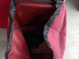 a red and black bag that is sitting on the floor
