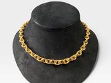 un chapeau noir orné d'une chaîne dorée