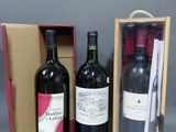 trois bouteilles de vin dans un coffret contenant un verre à vin