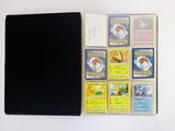 a lot of pokemon cards and a notebook on the table