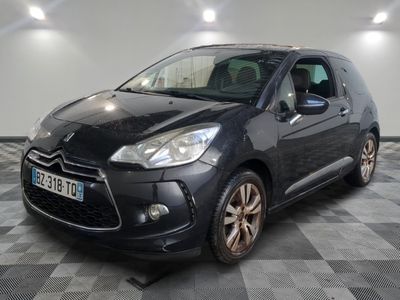 La Citroën noire est garée dans le garage, sur un sol à damier.