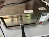 un micro-ondes posé sur une table dans la cuisine