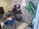 a desk with a computer and a chair in a room