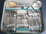a suitcase with a bunch of silverware in it