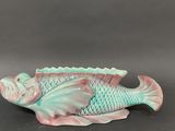 a ceramic fish that is sitting on a table