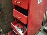a red chest of drawers that has tools in it