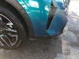 a close up of a blue car parked in a parking lot