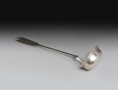 cuillère en argent avec un manche, posée sur une surface blanche