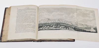 an open book with a picture of a mountain in the background