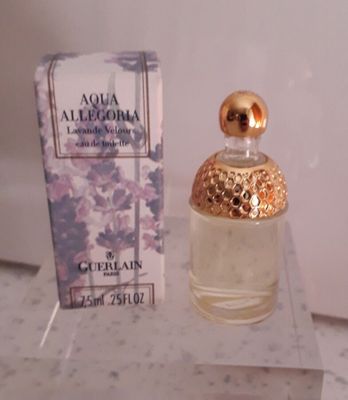un flacon de parfum posé sur une table à côté d'une boîte