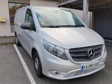 a silver van parked in a parking lot next to a building