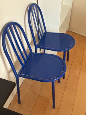 deux chaises bleues placées l'une à côté de l'autre sur un plancher en bois