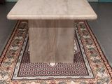 une table en marbre posée sur un tapis posé à même le sol
