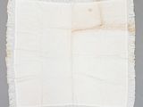 an old piece of cloth with fray edges on a gray surface